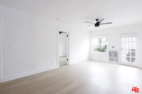 a view of a livingroom with a ceiling fan and window
