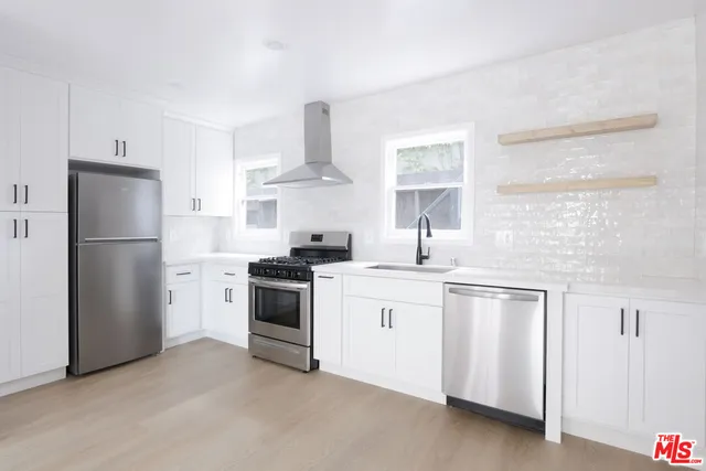 a kitchen with white cabinets and white appliances