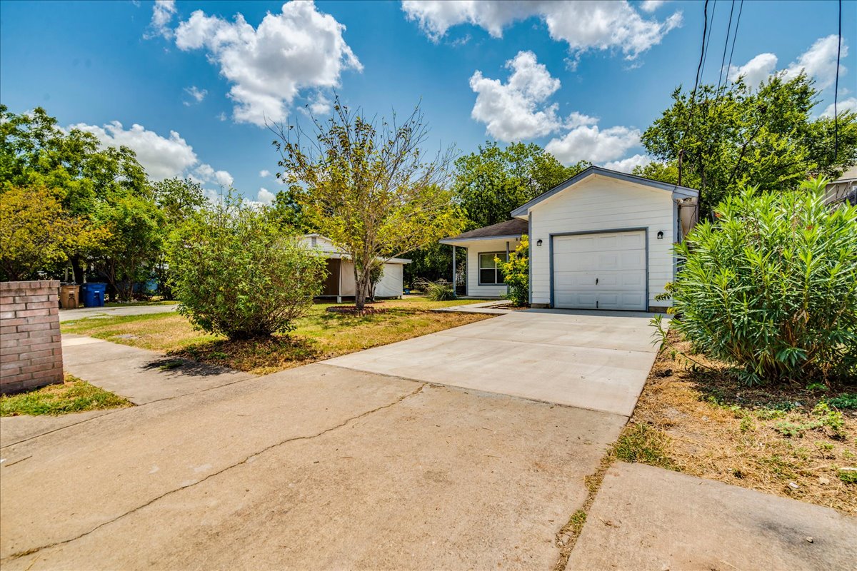 6801 Porter Street Austin, TX 78741 - Photo 30 of 30 A well-maintained concrete driveway leads to a charming white home with an attached garage.