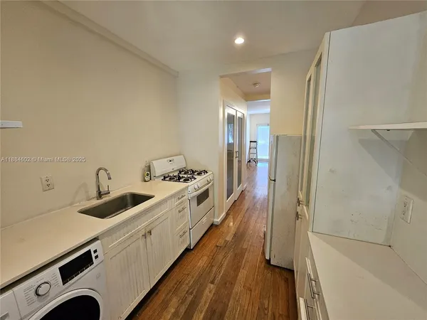 a view of a kitchen with a sink and wooden floor
