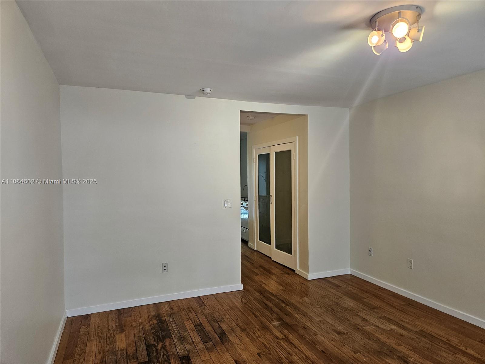 745 13th Street, Unit 16 Miami Beach, FL 33139 - Photo 12 of 27 a view of an empty room with wooden floor and a window