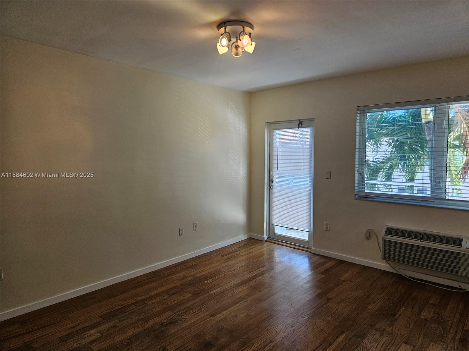 745 13th Street, Unit 16 Miami Beach, FL 33139 - Photo 13 of 27 a view of an empty room with wooden floor and a window