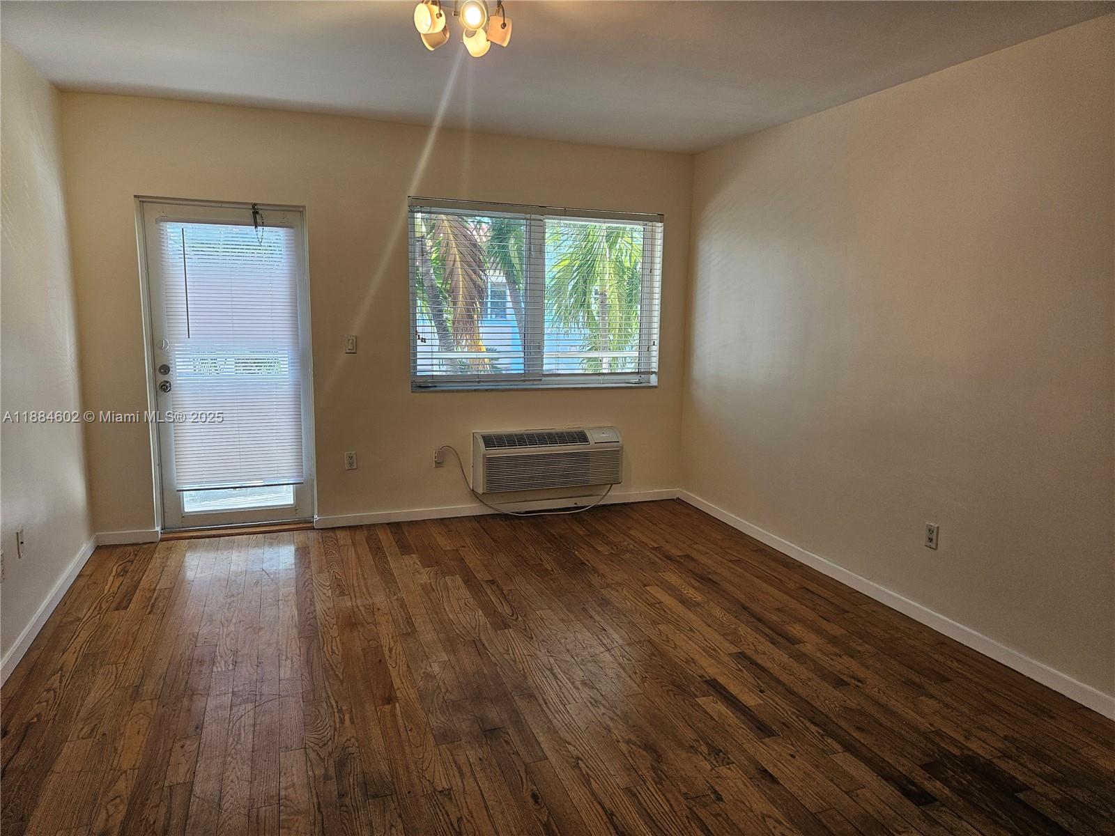 745 13th Street, Unit 16 Miami Beach, FL 33139 - Photo 2 of 27 an empty room with wooden floor and windows
