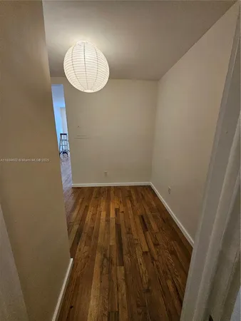 en empty room with wooden floor and white walls
