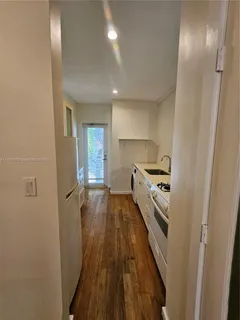 a kitchen with cabinets and wooden floor