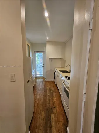 a kitchen with cabinets and wooden floor