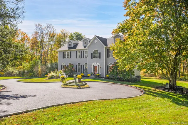a view of a house with a big yard and large trees