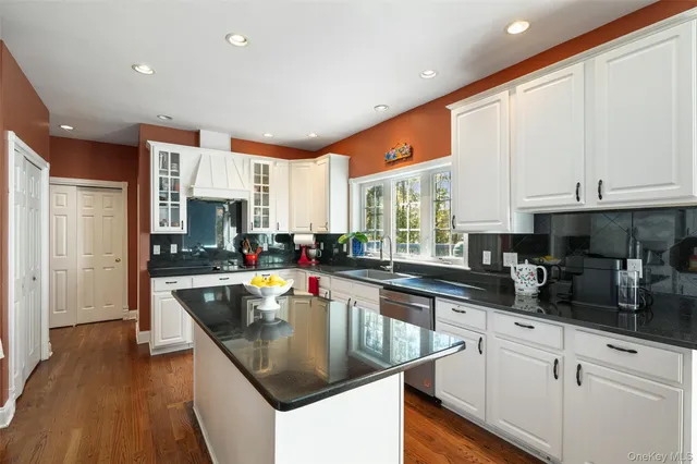 a kitchen with stainless steel appliances granite countertop a sink a stove and a refrigerator