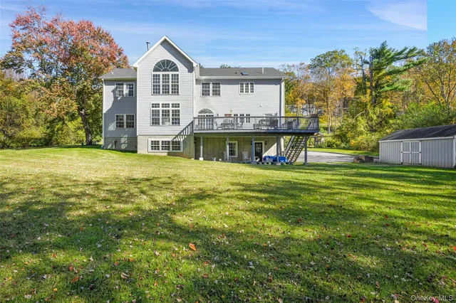 a view of a house with a big yard and large trees