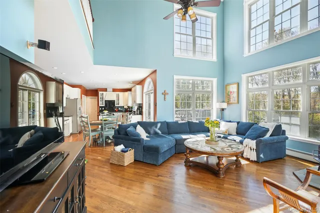 a living room with furniture floor to ceiling window and wooden floor