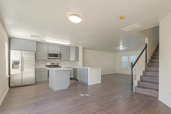 a kitchen with stainless steel appliances a refrigerator and a stove top oven