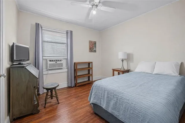a bedroom with a bed dresser and a flat tv screen
