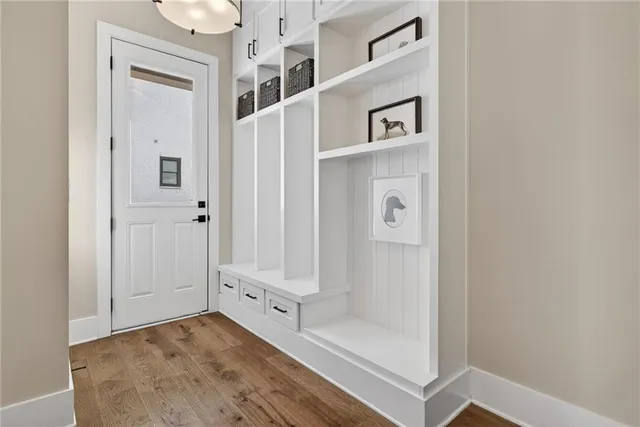 a living room with a fireplace windows and a wooden floor