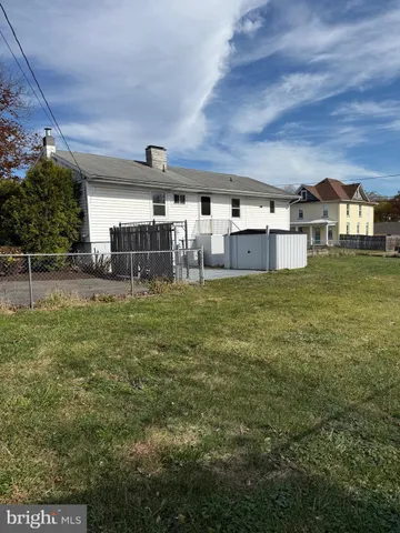 a view of a house with a big yard and sitting area