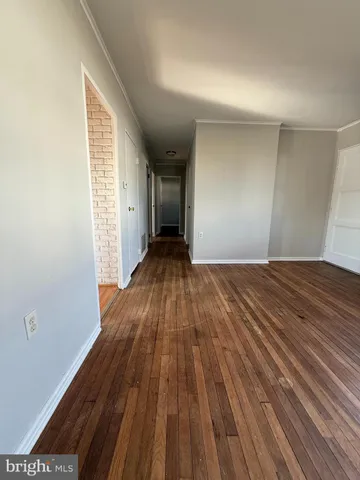 a view of a room with wooden floor and a window