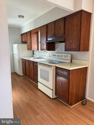 a kitchen with stainless steel appliances granite countertop a stove a refrigerator and wooden cabinets