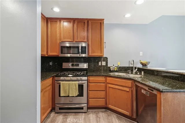 a kitchen with granite countertop a stove sink and cabinets