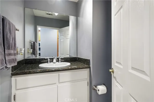 a bathroom with a granite countertop sink and a mirror