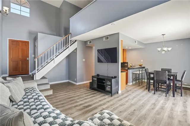 a living room with furniture and a dining table with wooden floor