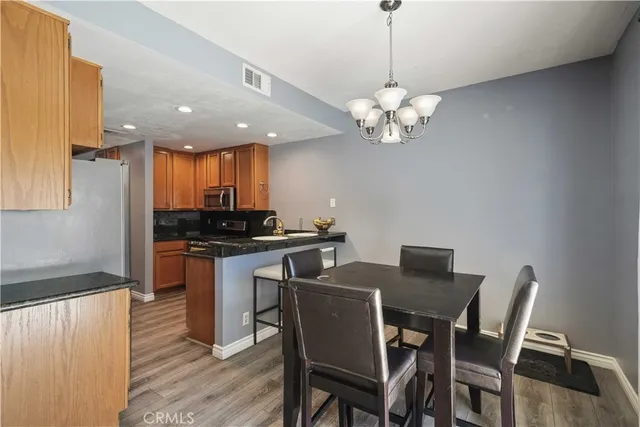 a view of a dining room with furniture a chandelier and wooden floor
