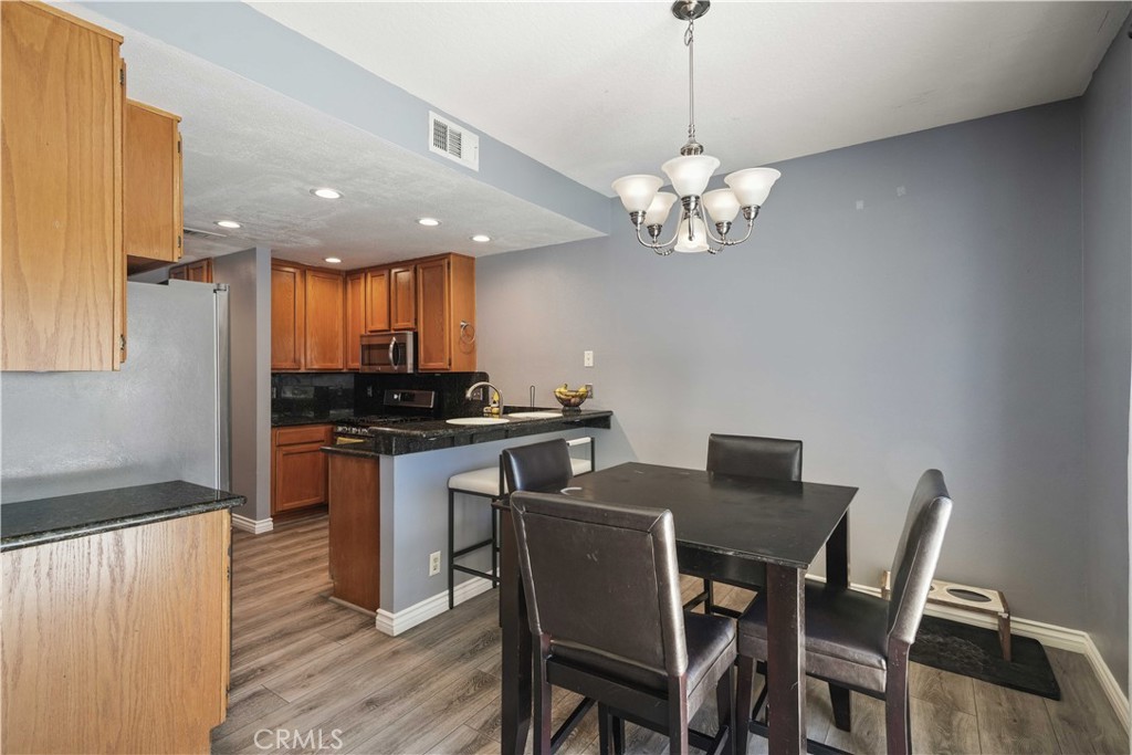 28345 Seco Canyon Road, Unit 97 Saugus, CA 91390 - Photo 9 of 38 a view of a dining room with furniture a chandelier and wooden floor