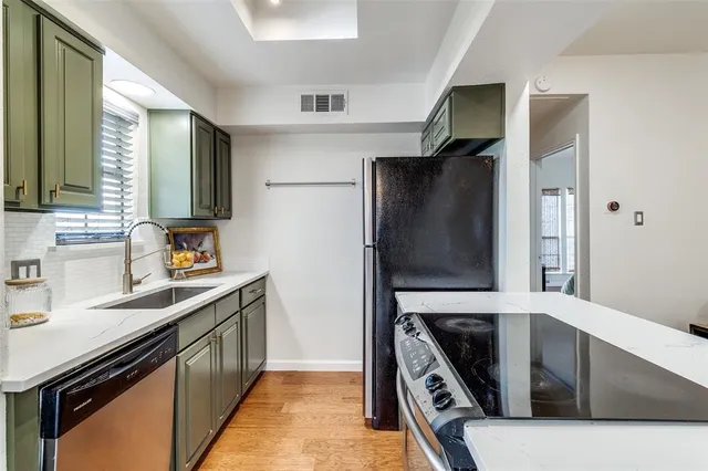 a kitchen with stainless steel appliances a stove a sink and a refrigerator