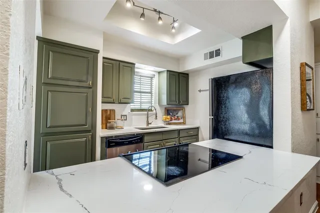 a kitchen with stainless steel appliances a sink and refrigerator