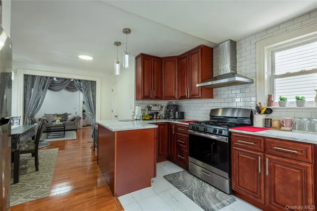 a kitchen with stainless steel appliances granite countertop a stove top oven a sink dishwasher and wooden cabinets with wooden floor