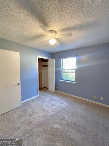 an empty room with windows and fan