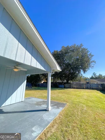 a view of swimming pool with seating area and trees in the background