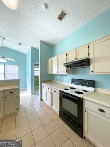 a kitchen with a stove sink and cabinets