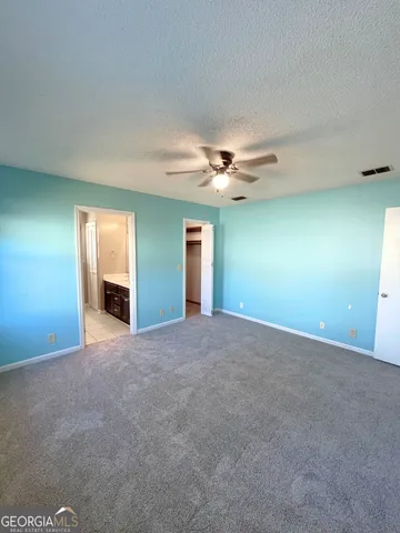 a view of an empty room with a chandelier fan