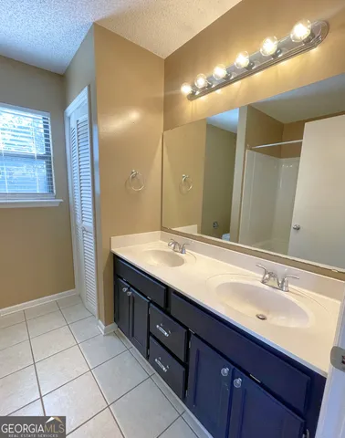 a bathroom with a double vanity sink a mirror and a shower