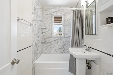 a bathroom with a sink a bathtub and shower