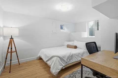 a bedroom with a bed and a wooden floor