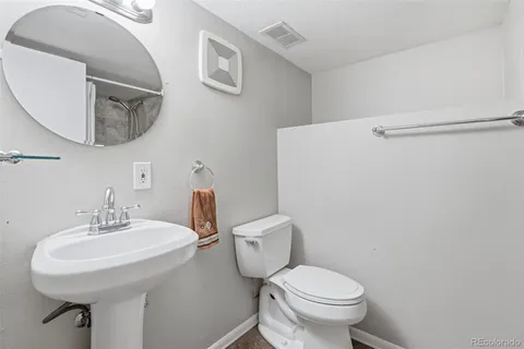 a bathroom with a sink mirror and toilet