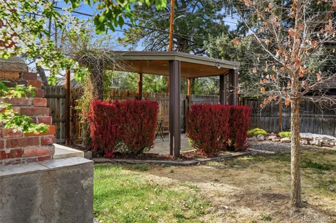 a patio with wooden floor a yard a fountain and a glass door