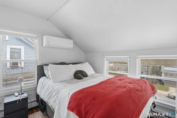 a bedroom with a large bed and two large window