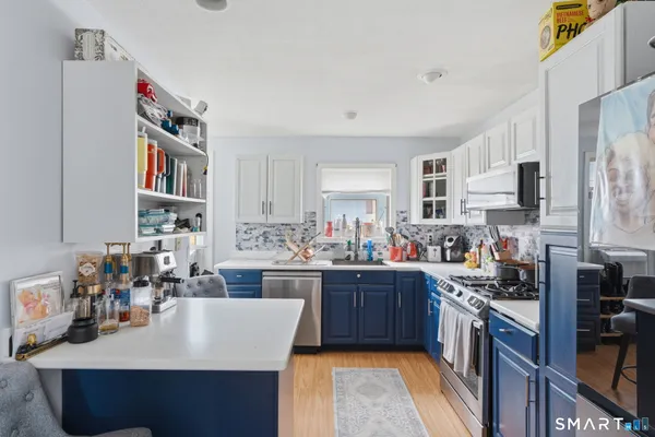 a kitchen with kitchen island granite countertop a sink stove and cabinets