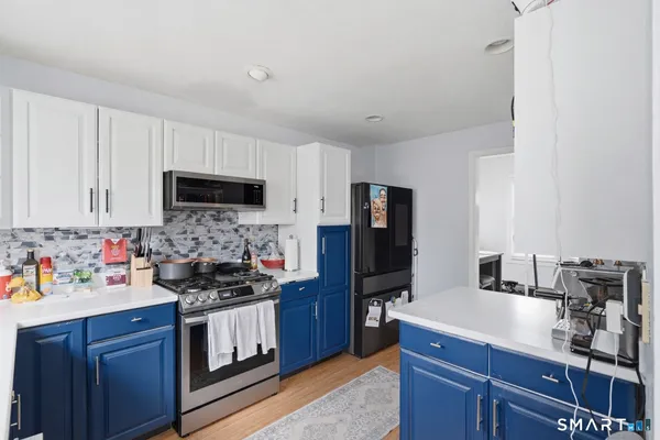 a kitchen with stainless steel appliances a stove microwave and refrigerator
