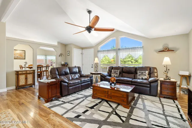 a living room with furniture a flat screen tv and a table