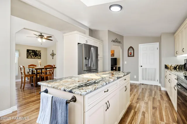 a kitchen with granite countertop white cabinets and white appliances