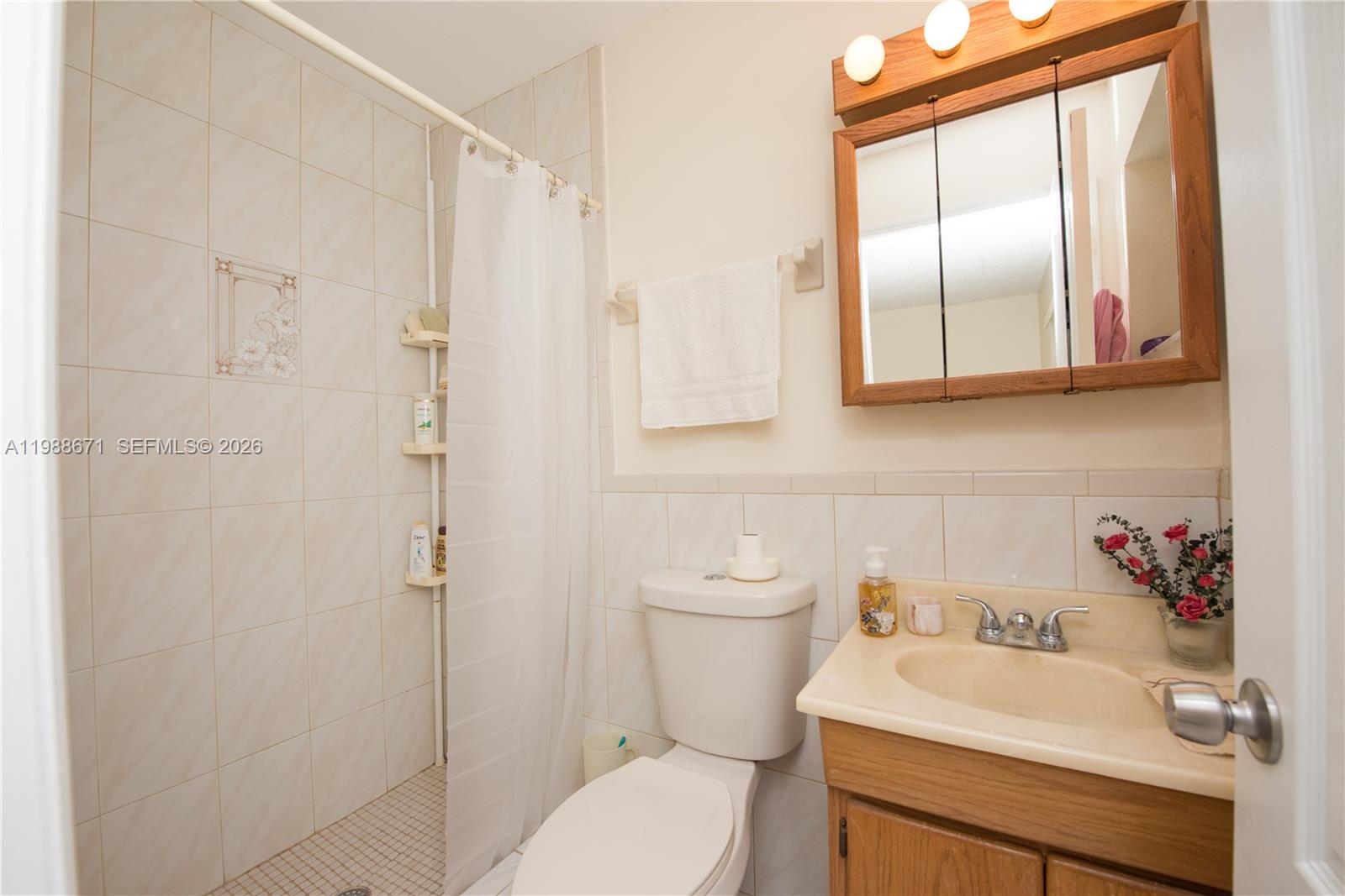 18900 Southwest 313th Street Homestead, FL 33030 - Photo 18 of 40 a bathroom with a sink a toilet and shower curtain