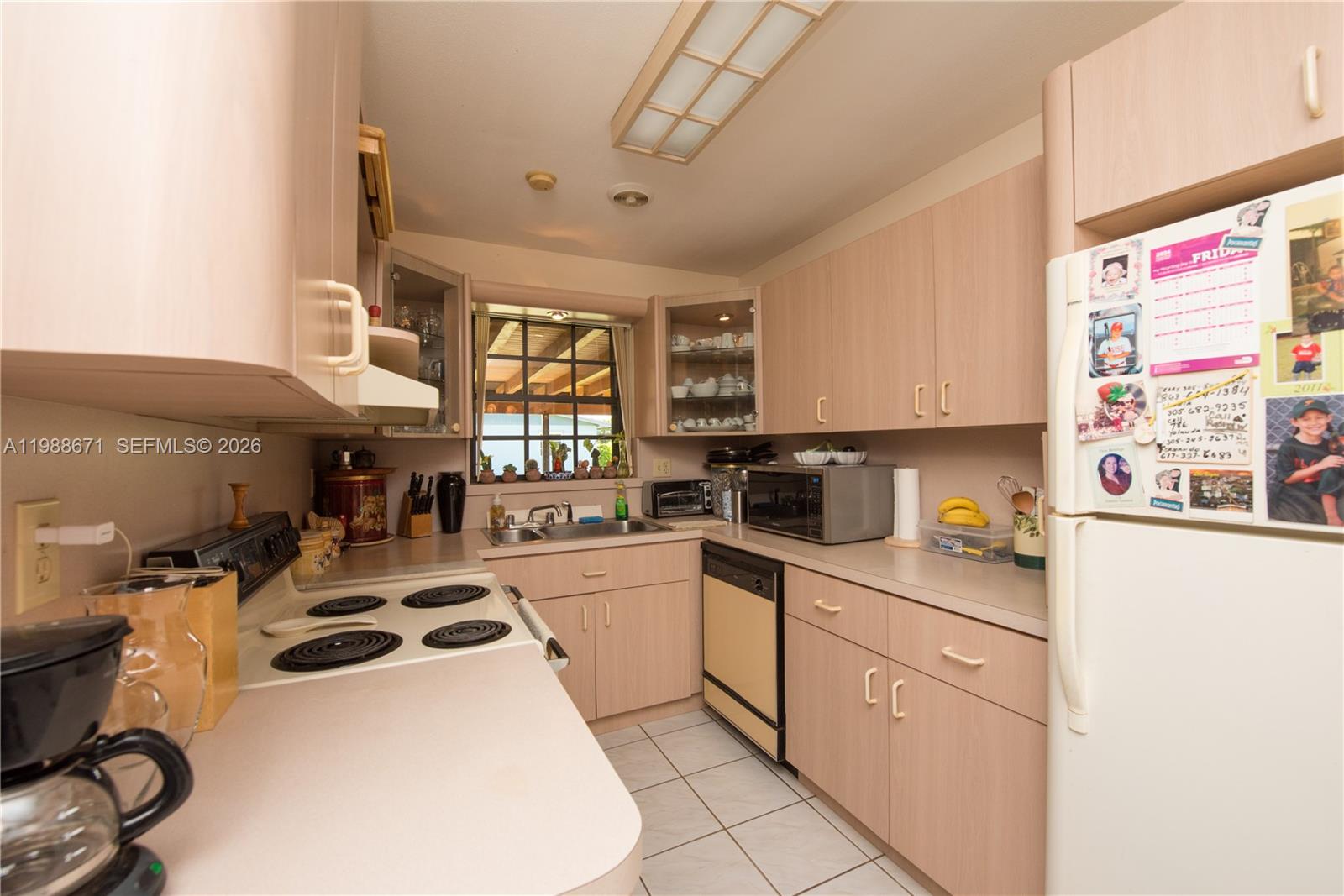 18900 Southwest 313th Street Homestead, FL 33030 - Photo 5 of 40 a kitchen with a sink a stove and white cabinets