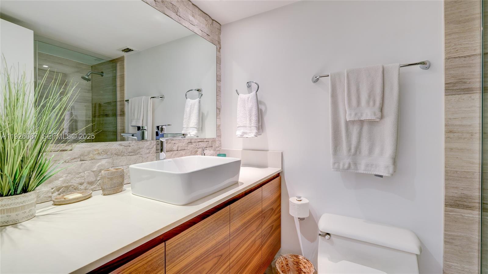 177 Ocean Ln Drive, Unit 707 Key Biscayne, FL 33149 - Photo 22 of 29 a bathroom with a sink a toilet a mirror and shower