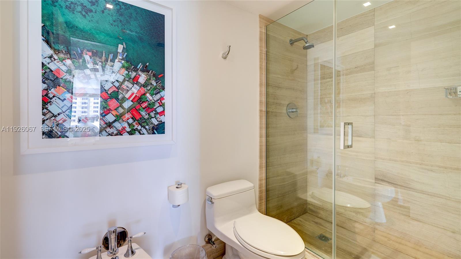 177 Ocean Ln Drive, Unit 707 Key Biscayne, FL 33149 - Photo 27 of 29 a bathroom with a toilet and a shower curtain