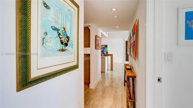 a view of a hallway with wooden floor and windows