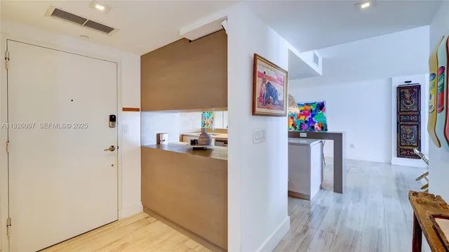 a view of a kitchen with fridge and wooden floor