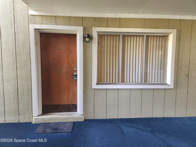 an empty room with a chandelier fan and a bathroom