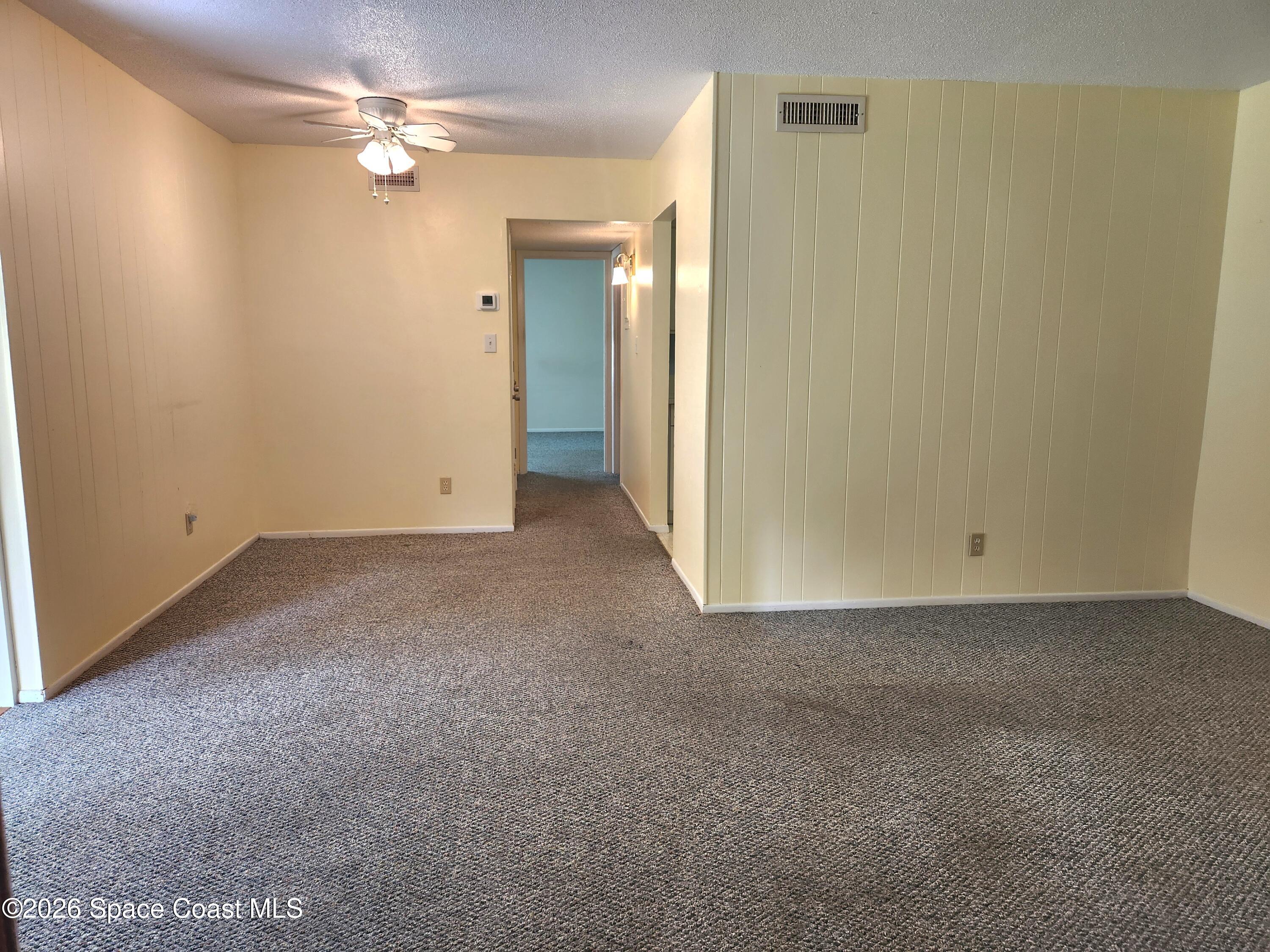 4304 London Town Rd Road, Unit 109 Titusville, FL 32796 - Photo 3 of 13 an empty room with a chandelier fan and a bathroom